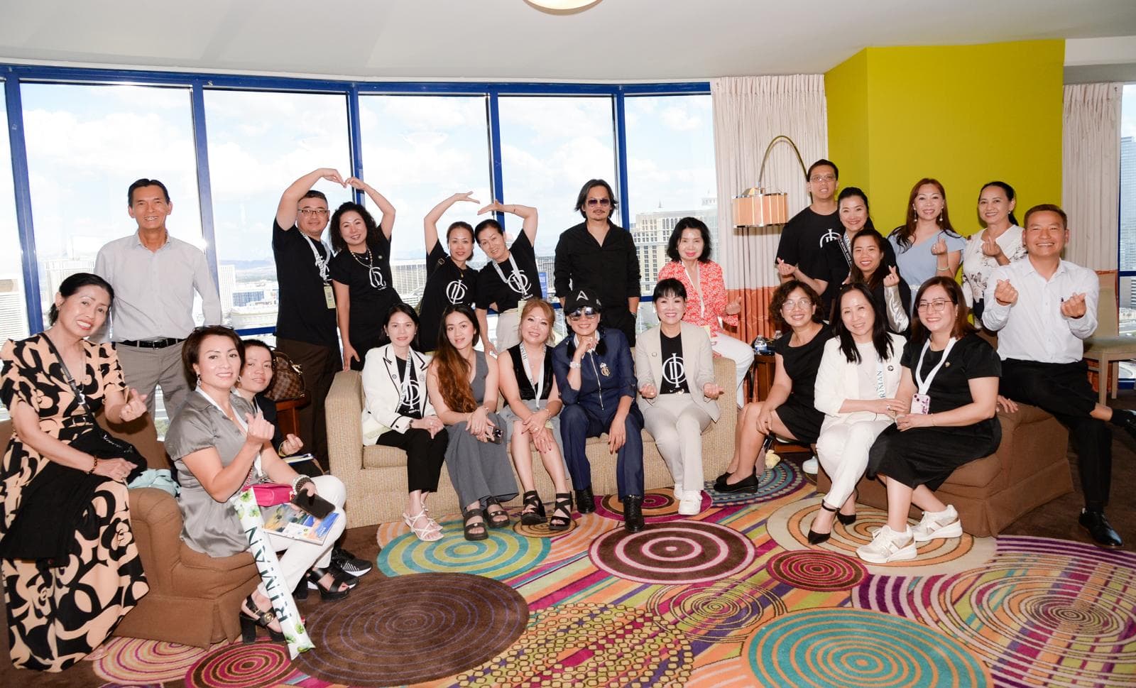 A community group posing together around sofas in a bright room.